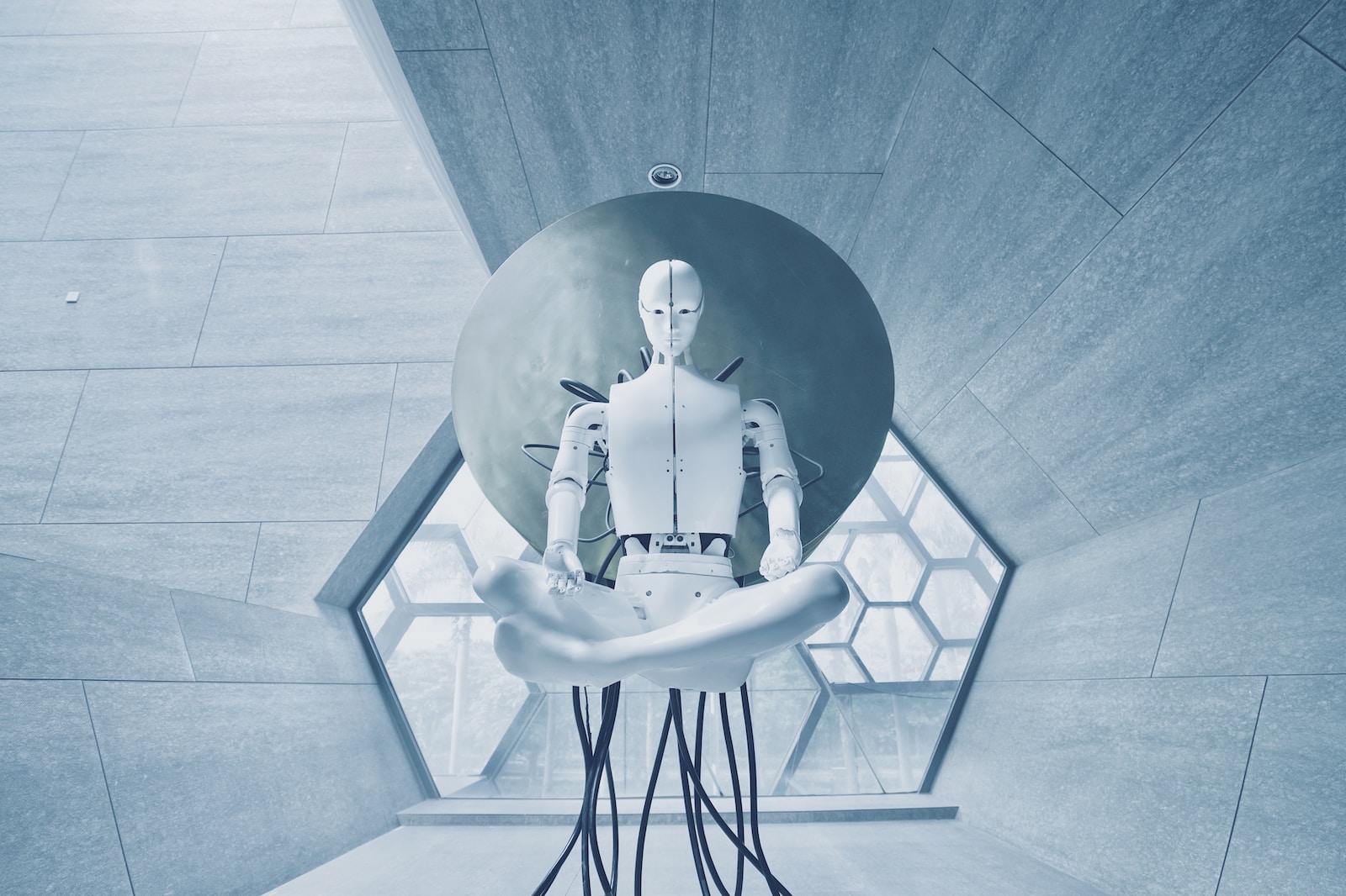 Futuristic robot meditating in a modern geometric room with hexagonal windows and sleek design