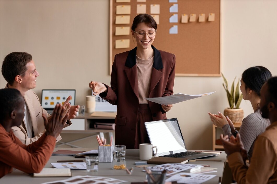 A woman presents to her colleagues, engaging them with her ideas and visuals in a professional setting.